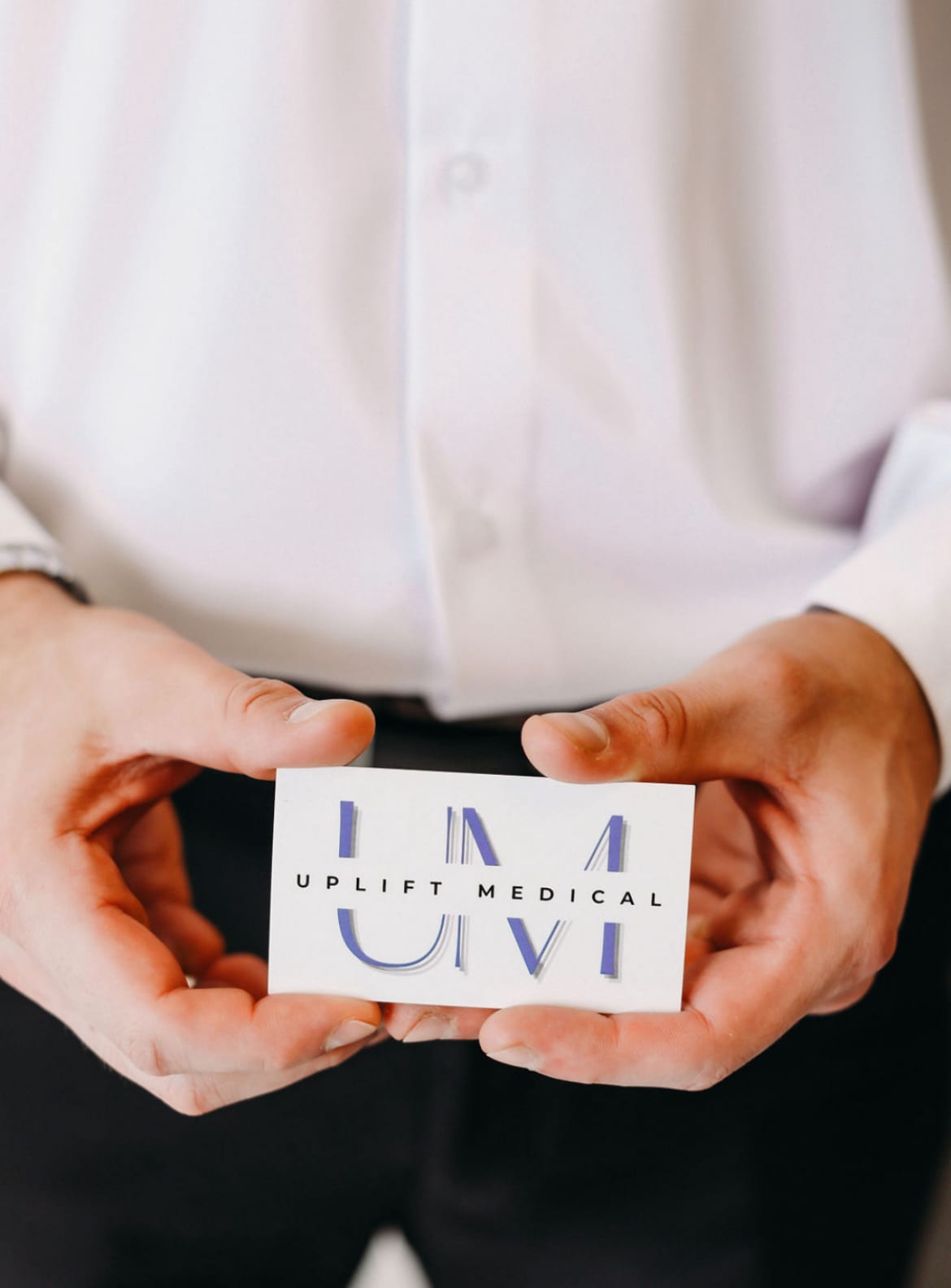 A person holding an Uplift Medical business card